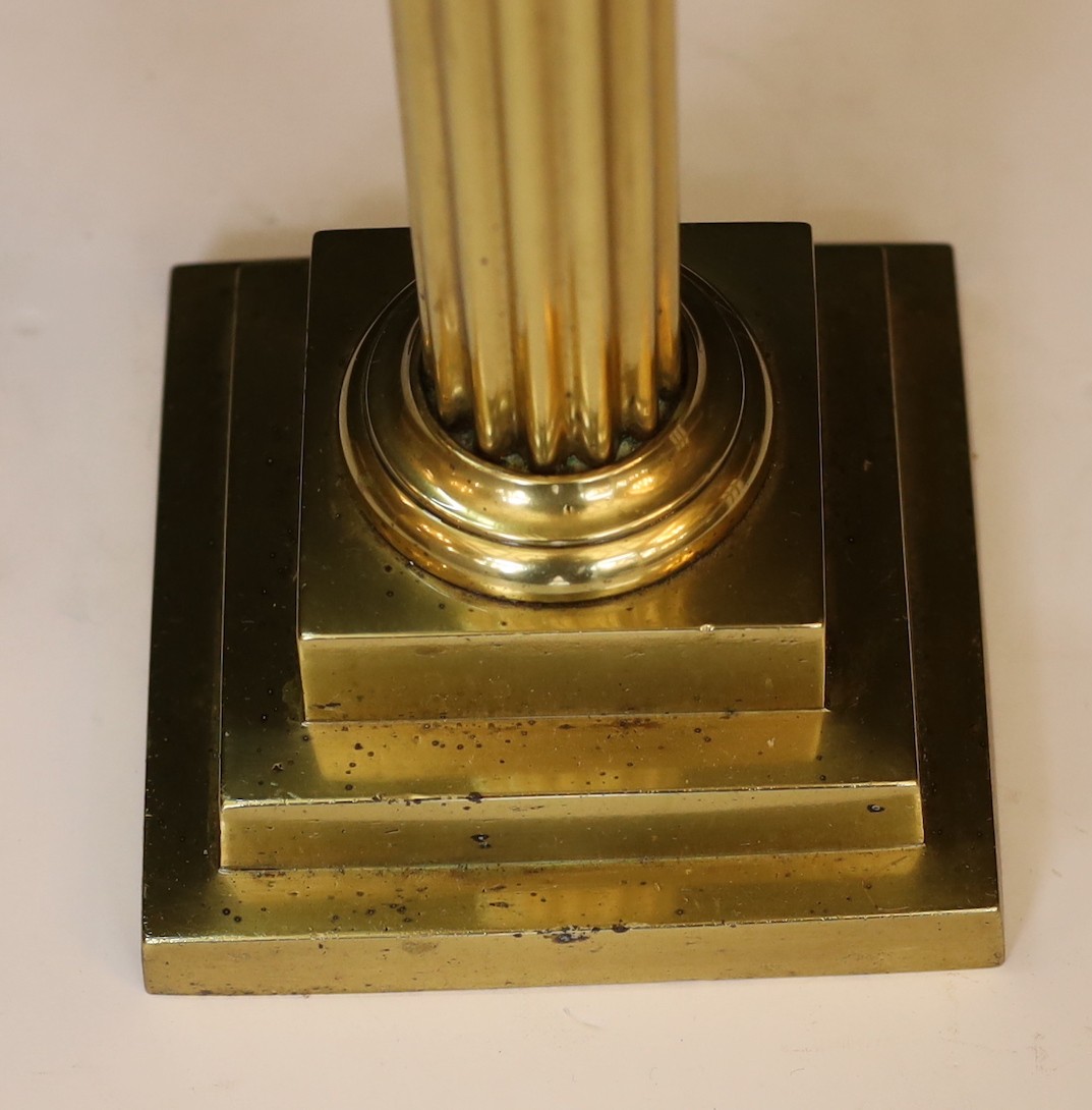 An Edwardian brass oil lamp with lobed glass reservoir, frosted globe and flue, height overall 74cm